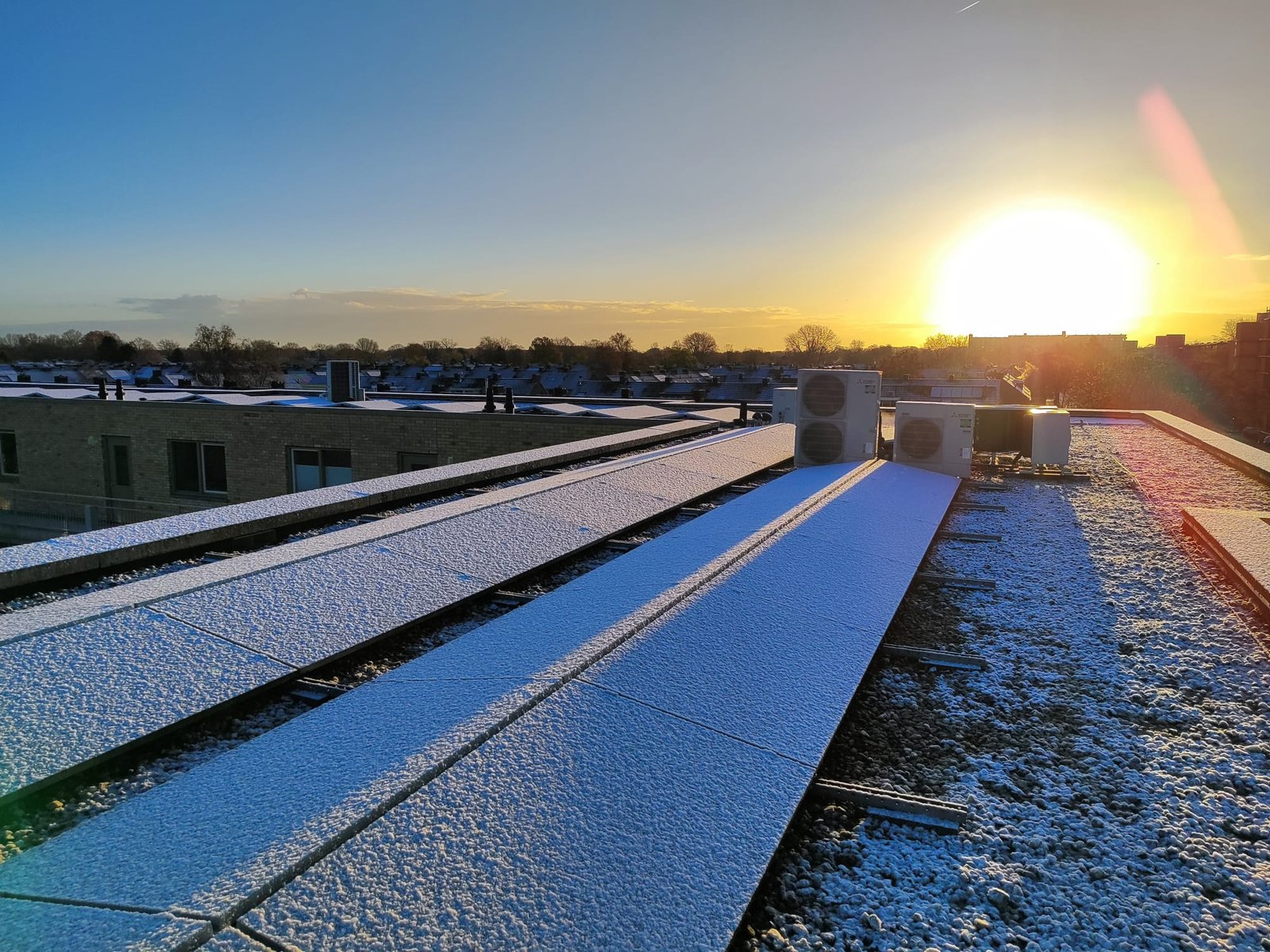 Zonnepanelen op dak bij zonsondergang